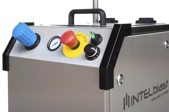 Zbliżenie panelu sterowania przemysłowej maszyny czyszczącej INTELblast, zaprojektowanej dla Usuwanie Graffiti Suchym Lodem, z niebieskim pokrętłem, wskaźnikiem, czerwonym przyciskiem zatrzymania awaryjnego, czarnym pokrętłem i uchwytem na powierzchni ze stali nierdzewnej.